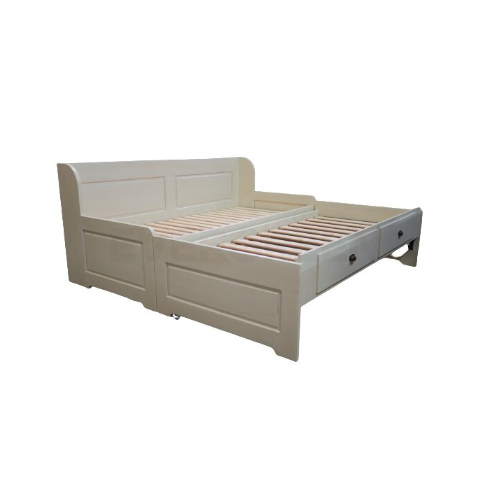 Rozkladacia posteľ z masívneho dreva s rozloženou prísteľkou a úložným priestorom v bielej farbe