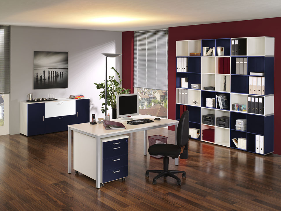 Kancelária zariadená dreveným nábytkom z masívu bielo modrej farby s kancelárskym stolíkom so šuplikmi, kancelárskou stoličkou, s komodou, so skriňou s poličkami na šanónmi a kancelárske potreby v priestore s veľkými oknami, s kvietkom na zemi a obrazom na stene.